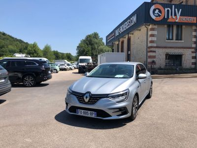 the silver car is parked in front of a building on the street