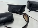 sunglasses and sunglasses case on a table with a pair of glasses