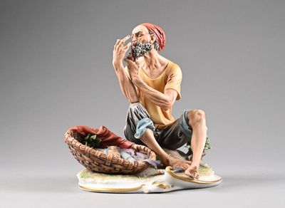 figurine représentant un homme assis sur un panier, tenant une bouteille de vin