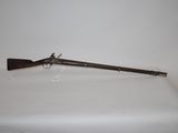 an old rifle with a wooden handle on a white table