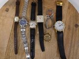 many different types of watches on a wooden board