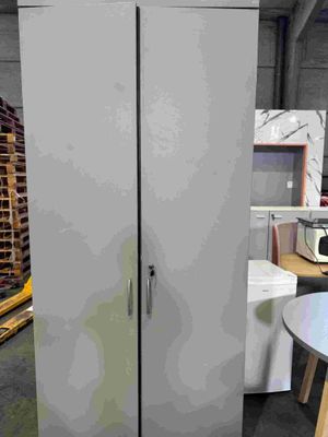 un grand réfrigérateur blanc dans une pièce où se trouvent une table et des chaises