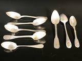 six silver spoons and two silver spoons on a black surface