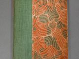 an orange and green book sitting on top of a gray table