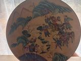 a person holding a plate with a painting on it