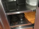 a stainless steel cabinet with plates and pans on it