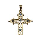 un pendentif en forme de croix en or, orné de pierres bleues sur fond blanc