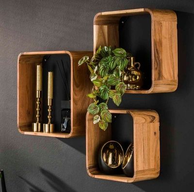 deux étagères en bois sur lesquelles sont disposées des plantes et des bougies, devant un mur noir