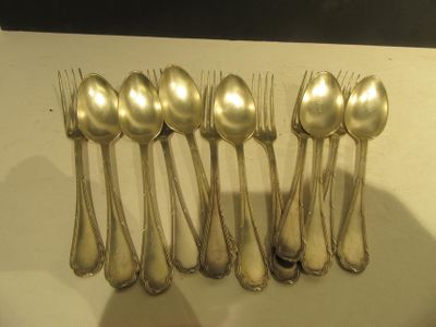 six cuillères en argent et six cuillères en argent posées sur une table