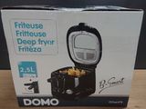 boxed box of domo deep fryer with lid open on wooden table