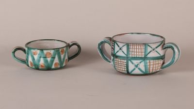 two small cups are sitting next to each other on a table