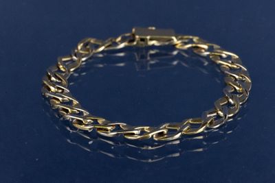 un gros plan d'un bracelet en or sur un fond bleu