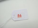 une étiquette portant le numéro 86, posée sur une table