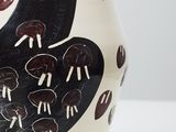 a black and white vase sitting on a white table