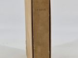 an old book sitting on top of a cardboard box on a white surface