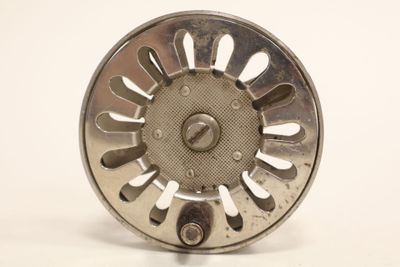 an image of a close up of a fly reel on a white surface