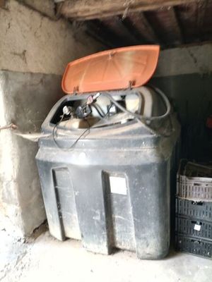 un bac noir avec un couvercle orange posé par terre à côté d'une caisse noire