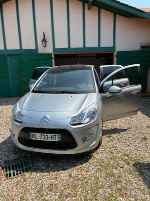 une voiture de couleur argentée garée devant un bâtiment