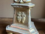 a statue of a person sitting on top of a wooden table