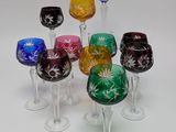 six wine glasses sitting in a row on a white surface