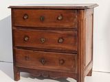 a small wooden chest of drawers on a white floor