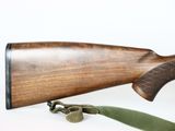 a rifle that is on the table with a green strap