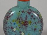 a small glass bottle with a red cap on it
