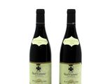 two bottles of wine sitting next to each other on a white surface
