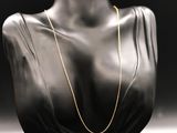 a black mannequin with a gold chain on it