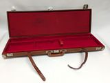 a red case with a brown handle on a white surface