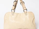 beige leather handbag on white background with strap