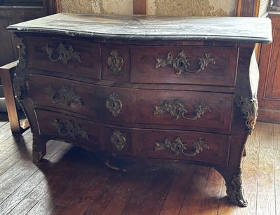 a wooden chest of drawers sitting on a hard wood floor