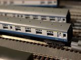 a model train on the tracks with other model trains in the background