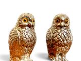 two figurines of owls sitting next to each other