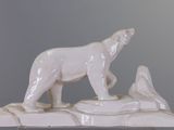 a white statue of a polar bear on top of a rock