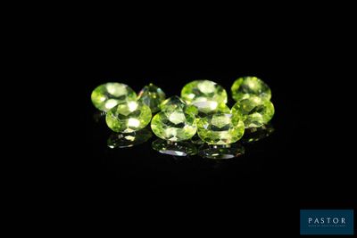 a close up of a group of green gems on a black surface