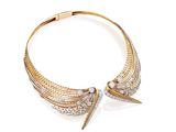 un gros plan d'un collier en or et diamants sur fond blanc