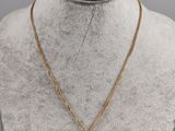 a gold necklace with a coin on a mannequin neck