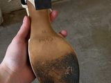 a person holding a pair of shoes in their hand