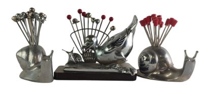a silver sculpture of a snail and a snail with red flowers
