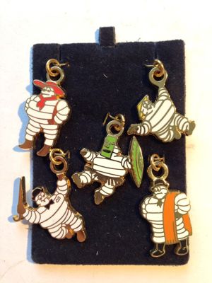 five charms of a mummy and a man with a surfboard on a black case