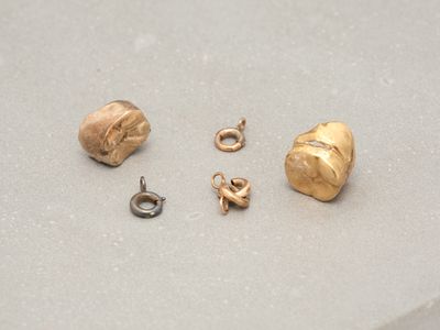 a gold earring and a gold earring on a table
