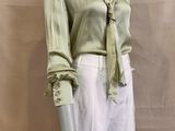 a mannequin wearing a green shirt and white skirt