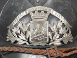 a metal helmet with a crown on it and a leather belt