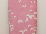 a pink ironing board with a pink cover on it
