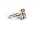 a close up of a silver ring with a diamond on it