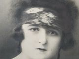 a black and white photo of a woman wearing a headband