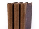 several old books stacked on top of each other on a white surface