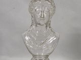 a glass bottle with a glass bust on it