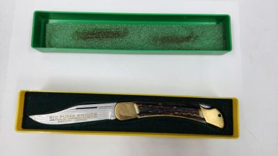un couteau dans une boîte verte à côté d'une boîte verte